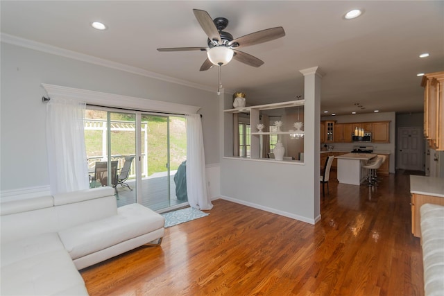 living area with crown molding, wood finished floors, ceiling fan, and recessed lighting