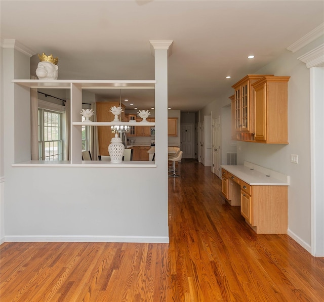kitchen featuring glass insert cabinets, baseboards, light countertops, recessed lighting, and wood finished floors