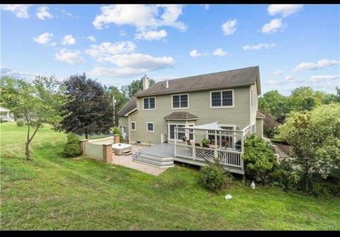 back of house with a yard and a deck