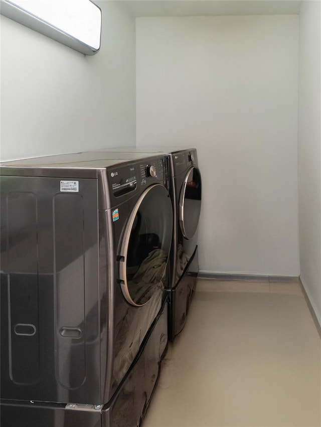 clothes washing area with washer and clothes dryer and laundry area