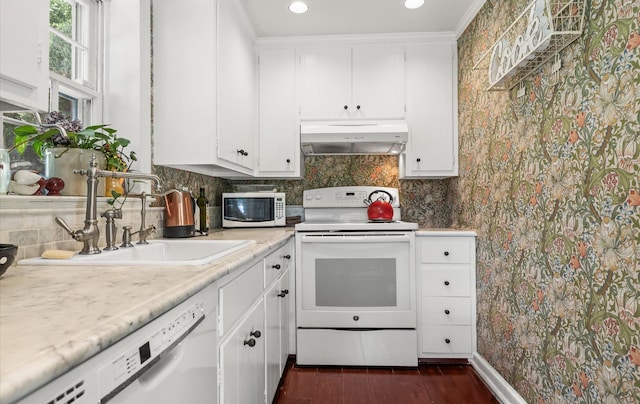 80 E Broadway, Roslyn, NY 11576 - kitchen with under cabinet range hood, white appliances, light countertops, white cabinets, and tasteful backsplash