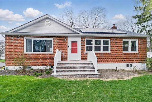 162 Berkshire Dr, Farmingville, NY 11738 - view of front of home featuring a chimney, roof mounted solar panels, a front lawn, and brick siding