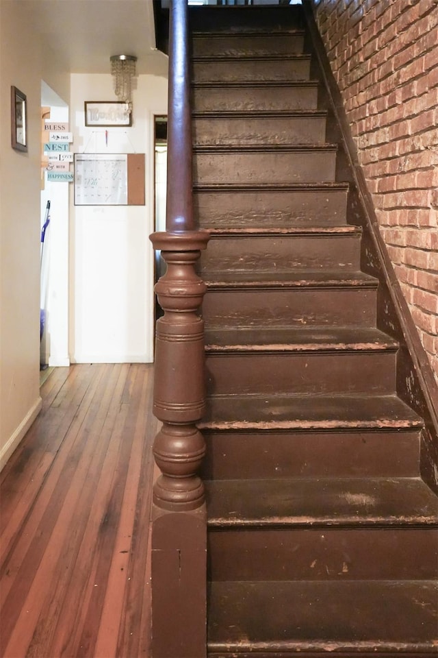 138 S Clark St, Newburgh, NY 12550 - staircase featuring hardwood / wood-style floors, baseboards, and brick wall