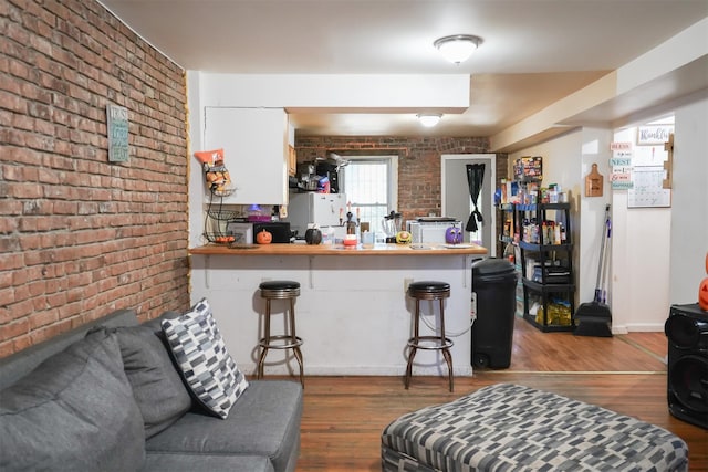 138 S Clark St, Newburgh, NY 12550 - living area with brick wall, baseboards, and wood finished floors