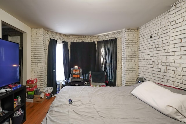 138 S Clark St, Newburgh, NY 12550 - bedroom with brick wall and wood finished floors