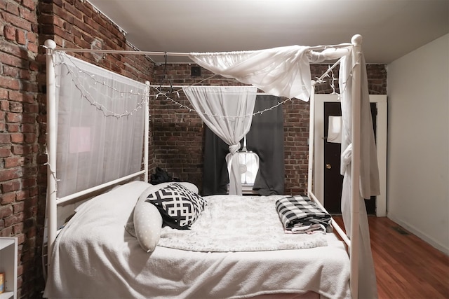 138 S Clark St, Newburgh, NY 12550 - bedroom with brick wall, baseboards, and wood finished floors