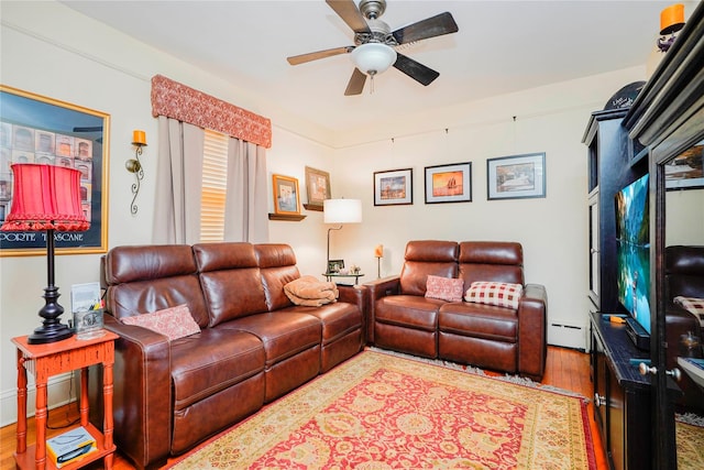 living area featuring a baseboard radiator, a ceiling fan, and wood finished floors