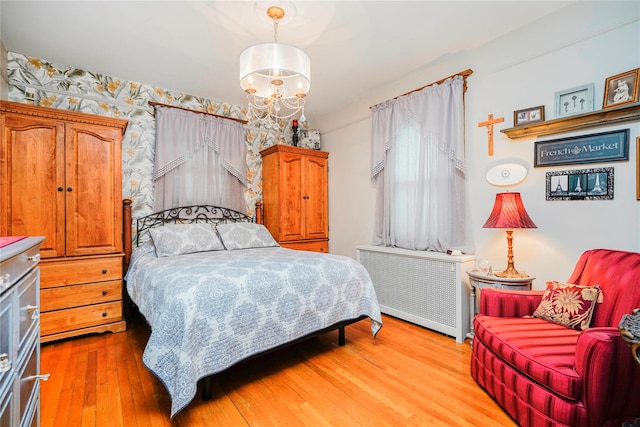 bedroom featuring light wood-style flooring, radiator, and wallpapered walls