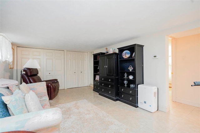 living area featuring light tile patterned floors and baseboards
