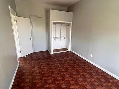 unfurnished bedroom with a closet and baseboards