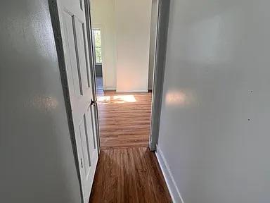 hallway featuring baseboards and dark wood-style floors