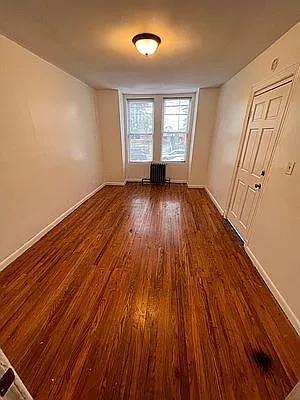 empty room with baseboards and wood finished floors