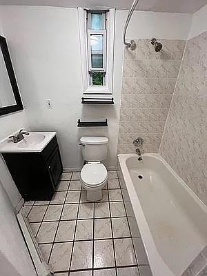 bathroom featuring tile patterned flooring, shower / bathtub combination, vanity, and toilet