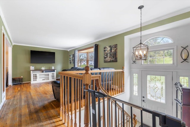 entrance foyer featuring hardwood / wood-style floors, a chandelier, and ornamental molding