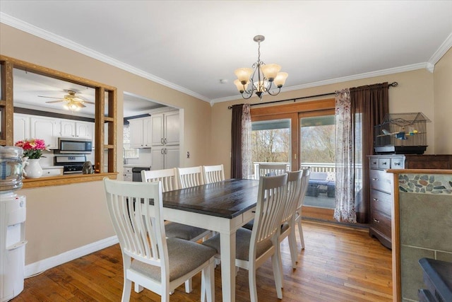 dining space featuring baseboards, crown molding, light wood-style floors, and ceiling fan with notable chandelier