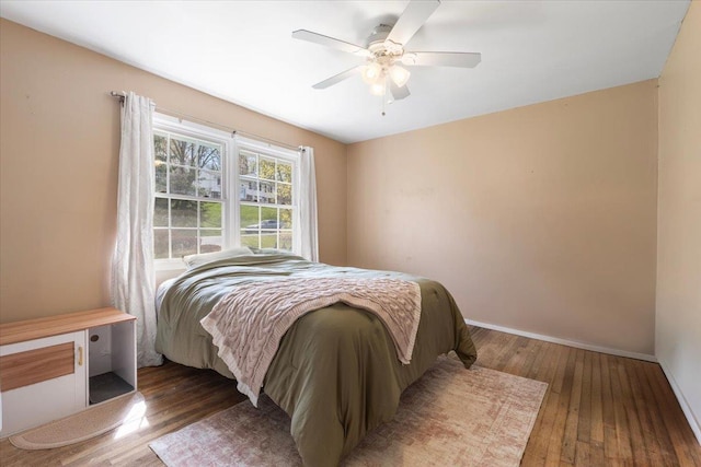 bedroom featuring wood-type flooring, a ceiling fan, and baseboards