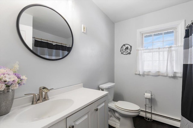bathroom featuring baseboard heating, vanity, and toilet