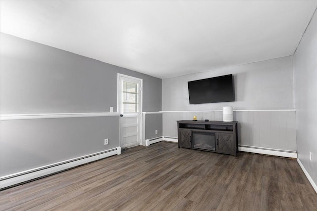 unfurnished living room featuring a baseboard radiator, baseboards, a wainscoted wall, and wood finished floors
