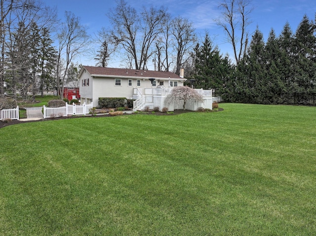 back of property featuring a yard, fence, and a chimney