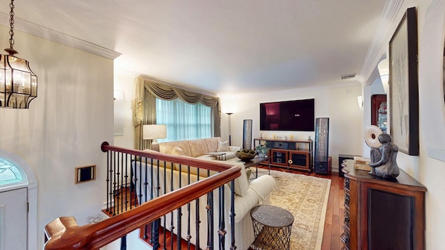 living area with crown molding, visible vents, and wood-type flooring