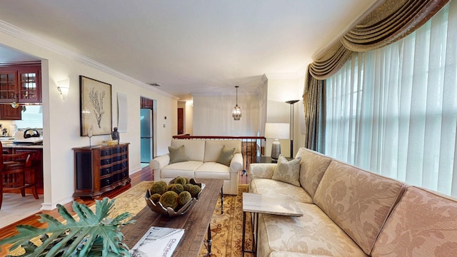 living area with crown molding, wood finished floors, and visible vents