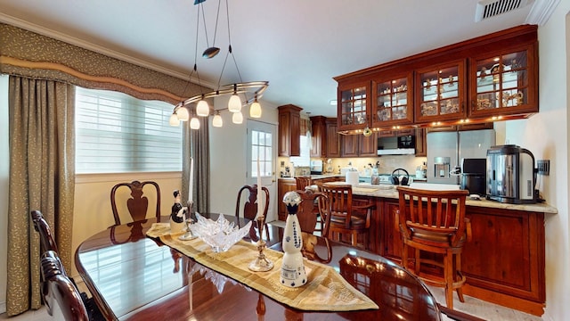 dining space featuring ornamental molding, visible vents, and light wood finished floors
