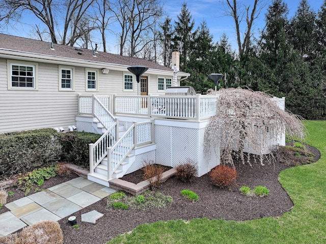 rear view of house featuring a wooden deck and a chimney
