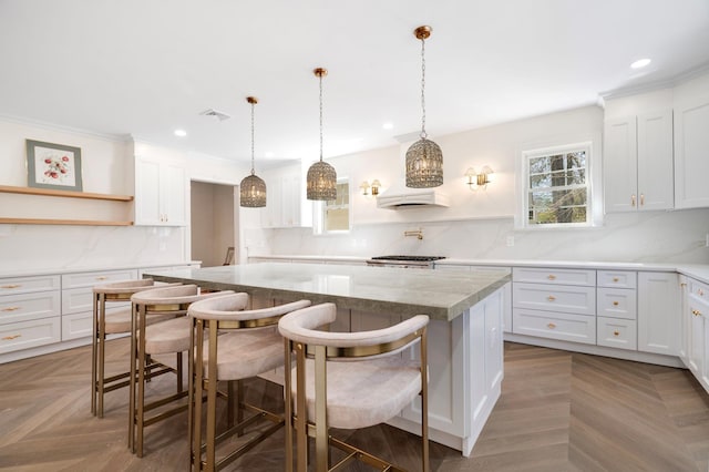 56 Drake Rd, Scarsdale, NY 10583 - kitchen with open shelves, a center island, recessed lighting, tasteful backsplash, and white cabinetry