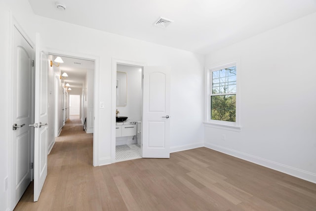 56 Drake Rd, Scarsdale, NY 10583 - unfurnished bedroom with light wood-type flooring, baseboards, and ensuite bath