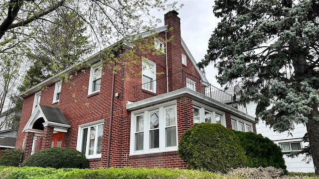 view of property exterior featuring brick siding and a chimney