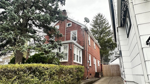 view of home's exterior featuring brick siding and a chimney