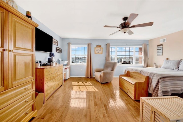 bedroom with a ceiling fan, light wood finished floors, and visible vents