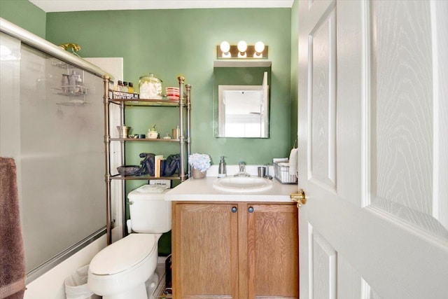 full bathroom with vanity, a shower with shower door, and toilet