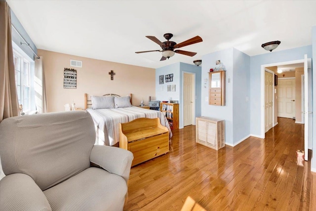 bedroom featuring baseboards, a ceiling fan, light wood-style floors, and visible vents