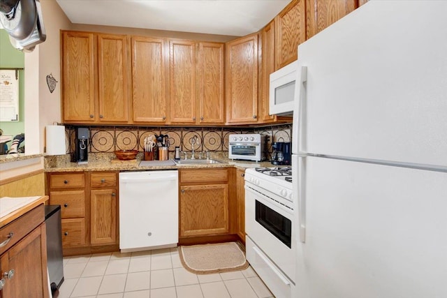 kitchen featuring tasteful backsplash, a sink, white appliances, a toaster, and light countertops