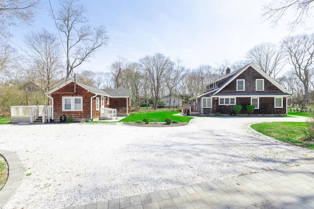 572A Montauk Hwy, Westhampton Beach, NY 11978 - view of front facade featuring gravel driveway, a chimney, a front yard, and a deck