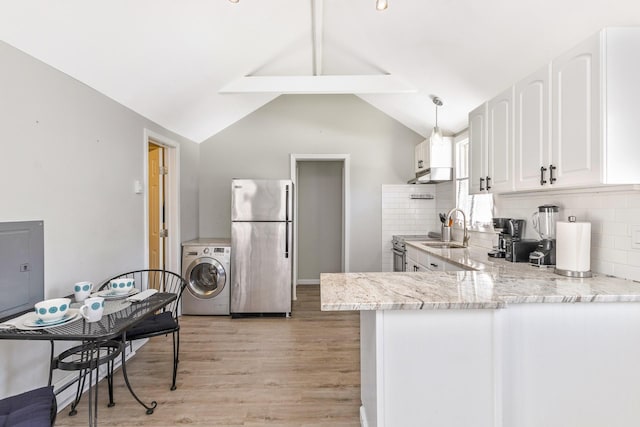 572A Montauk Hwy, Westhampton Beach, NY 11978 - kitchen with a sink, stainless steel appliances, washer / clothes dryer, under cabinet range hood, and light stone countertops