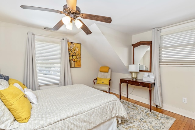 572A Montauk Hwy, Westhampton Beach, NY 11978 - bedroom with lofted ceiling, visible vents, a ceiling fan, baseboards, and hardwood / wood-style flooring