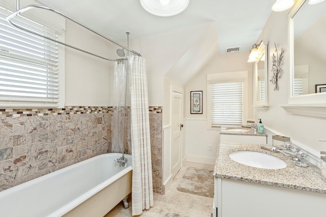 572A Montauk Hwy, Westhampton Beach, NY 11978 - bathroom featuring a sink, wainscoting, a tub to relax in, a shower with curtain, and double vanity