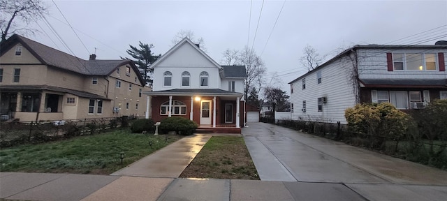 view of front of property featuring a detached garage, fence, an outdoor structure, cooling unit, and a front lawn