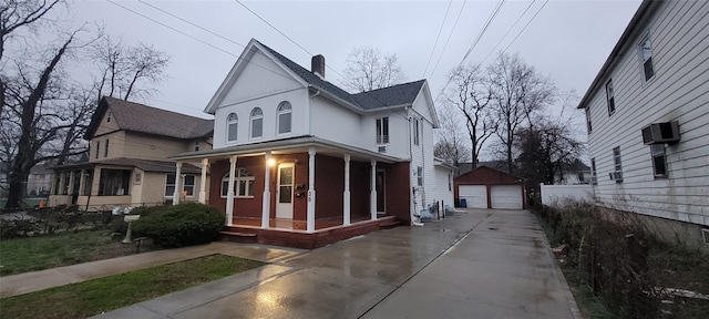 view of home's exterior with a porch, a chimney, a detached garage, and an outdoor structure
