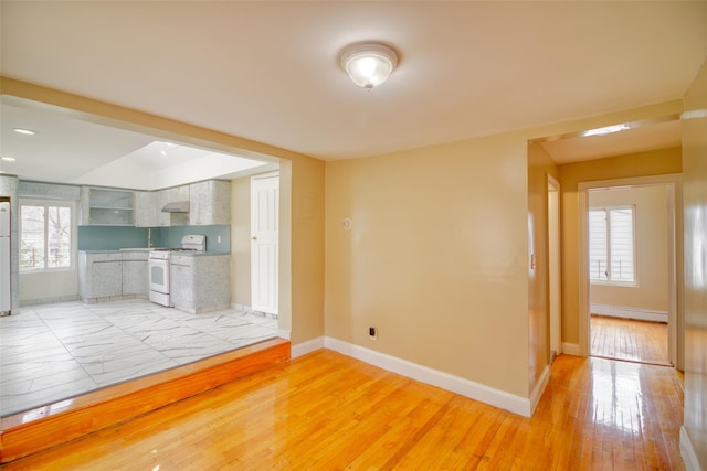interior space with baseboards, light wood finished floors, and a baseboard heating unit