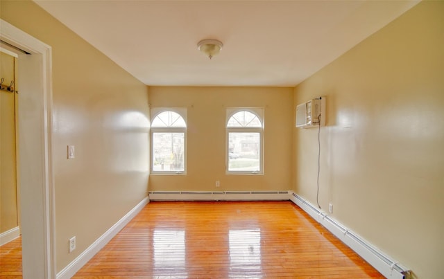 unfurnished room featuring baseboards, an AC wall unit, a baseboard radiator, baseboard heating, and light wood finished floors
