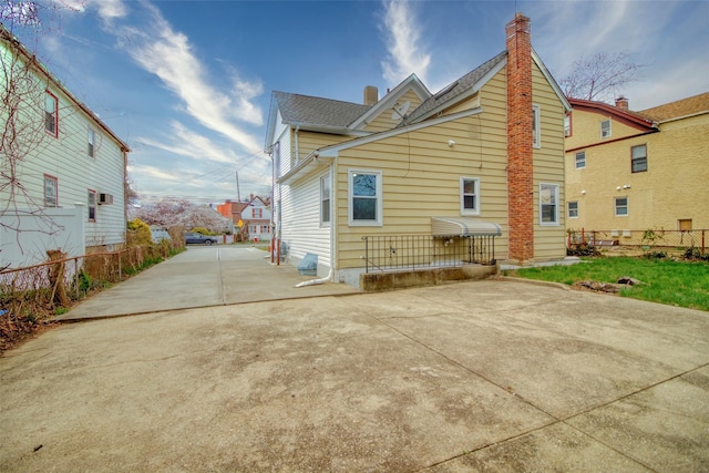 back of property with a patio area, fence, and a chimney