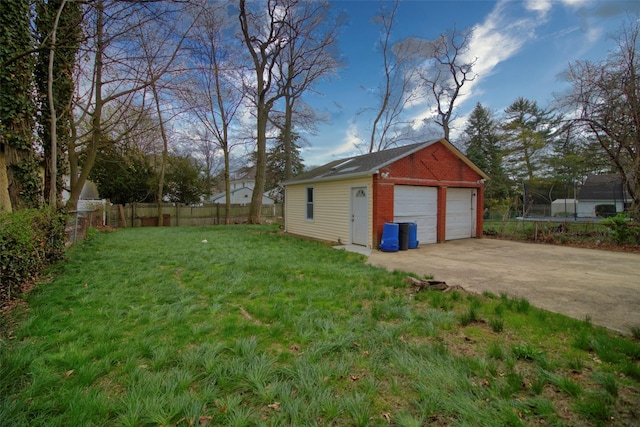 detached garage with a trampoline and fence