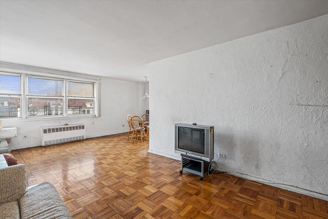 90-59 56th Ave Unit 2J, Elmhurst, NY 11373 - unfurnished living room with a textured wall and radiator