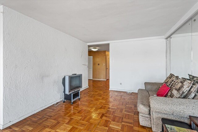 90-59 56th Ave Unit 2J, Elmhurst, NY 11373 - living area featuring a textured wall and baseboards