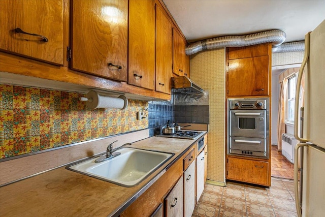 90-59 56th Ave Unit 2J, Elmhurst, NY 11373 - kitchen with oven, gas cooktop, a sink, brown cabinetry, and a warming drawer