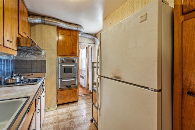 90-59 56th Ave Unit 2J, Elmhurst, NY 11373 - kitchen with brown cabinetry, light countertops, a sink, a warming drawer, and stainless steel appliances