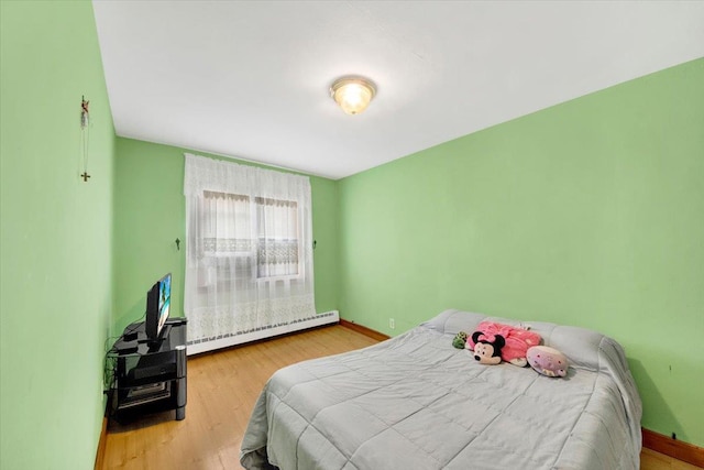 2559 Seymour Ave, Bronx, NY 10469 - bedroom with baseboards, baseboard heating, and wood finished floors